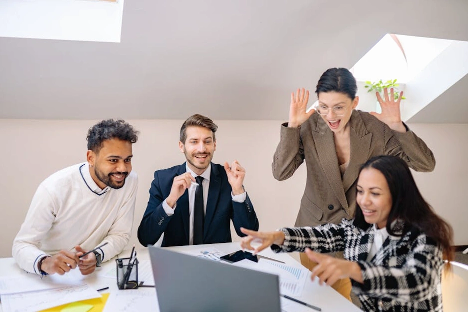 A diverse team of marketing professionals collaborating around a whiteboard in a modern office.